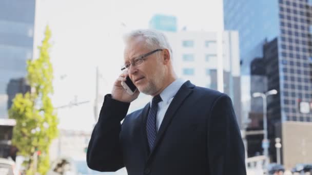 senior businessman calling on smartphone in city - Materiał filmowy, wideo