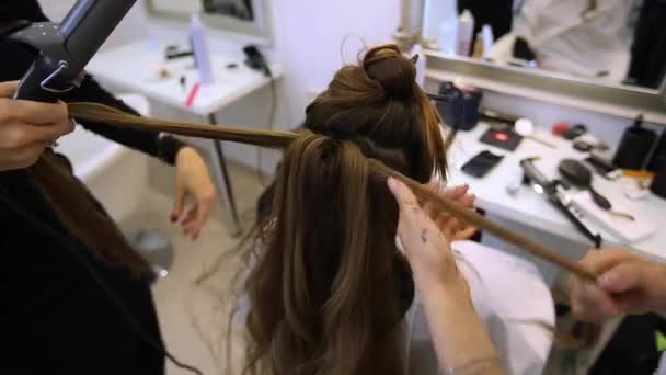 Stylista włosów sprawia, że włosy sukienka piękna dziewczyna w salonie piękności - Materiał filmowy, wideo