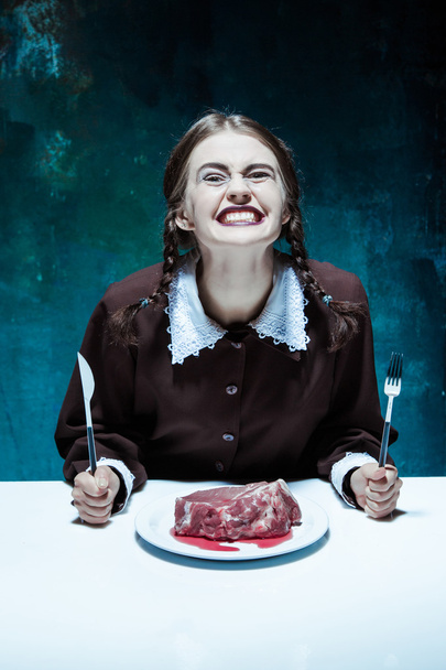 Bloody Halloween theme: crazy girl with a knife, fork and meat - Zdjęcie, obraz