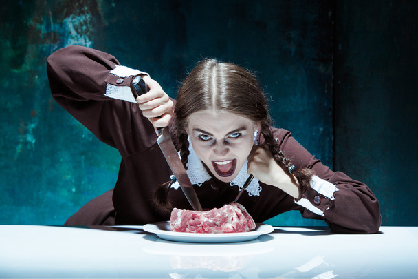 Bloody Halloween theme: crazy girl with a knife, fork and meat - Zdjęcie, obraz