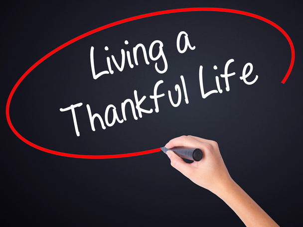 Woman Hand Writing Living a Thankful Life with a marker over tra - Photo, Image