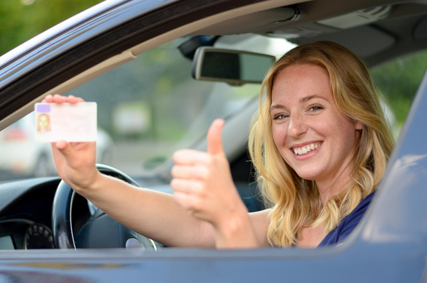 junge blonde Frau zeigt ihren Führerschein - Foto, Bild