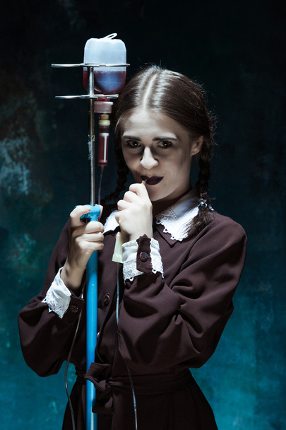 Portret van een jong meisje op school uniform als een vampier vrouw - Foto, afbeelding
