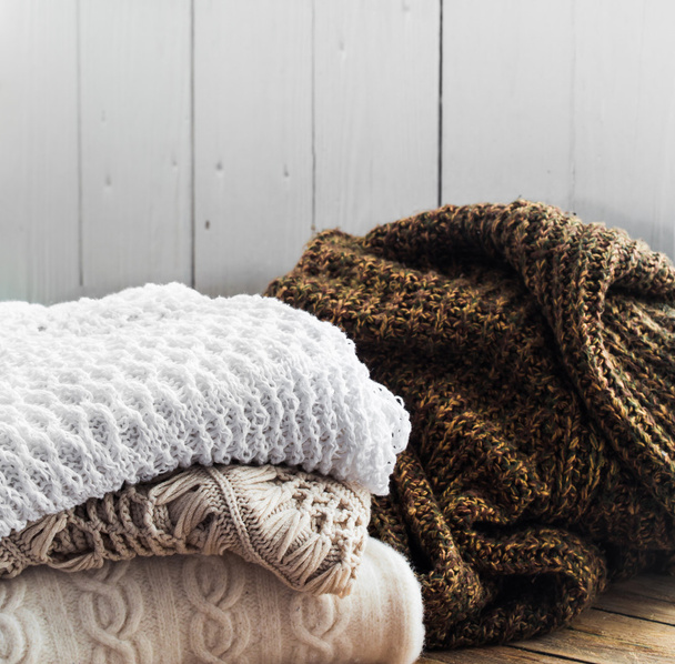 Вязаный удобный свитер лежит на деревянном фоне
 - Фото, изображение