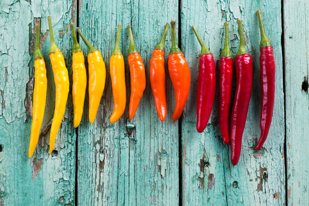 many vibrant colors on peppers , old wooden background - Valokuva, kuva