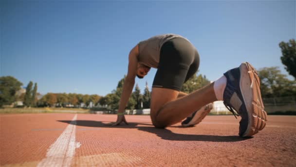 männlicher Athlet läuft aus der vorgegebenen Position an der Landebahn - Filmmaterial, Video