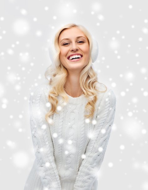smiling young woman in winter earmuffs and sweater - Foto, Bild