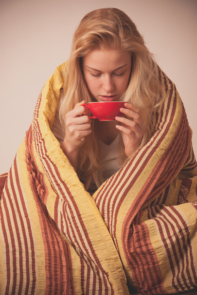 Sick woman sitting on bad wrapped in a blanket feeling ill, has  - Photo, image