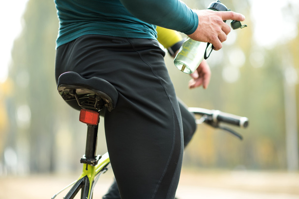 Cyclist holding bottle of water  - Photo, Image