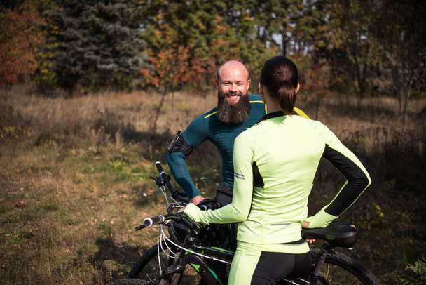 秋の公園で自転車のカップル - 写真・画像