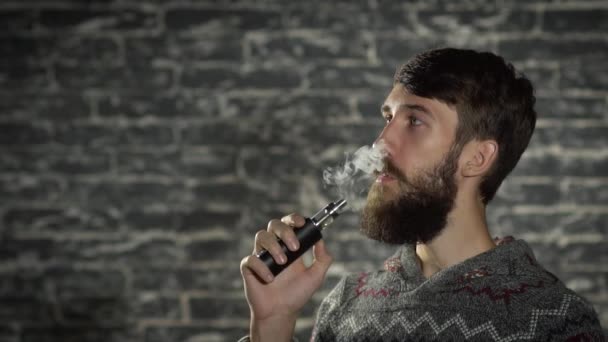 Mladý muž s vousy vaping elektronická cigareta. Vaper bokovky kouře odpařovač v pomalém pohybu  - Záběry, video