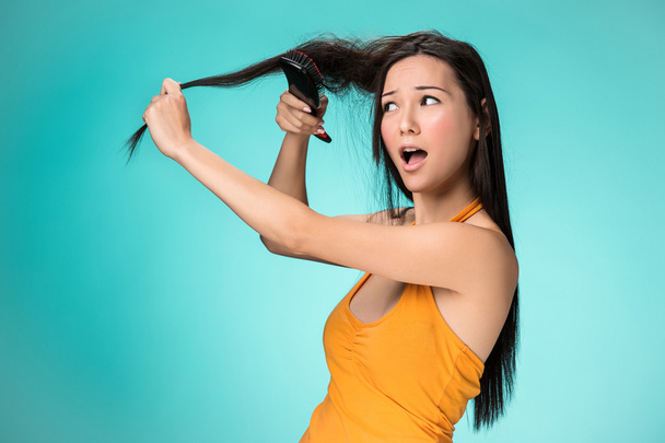 Frustrated young woman having a bad hair - 写真・画像