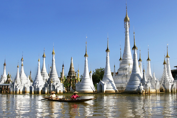 仏舎利塔の背景にミャンマーの伝統的なボート - 写真・画像