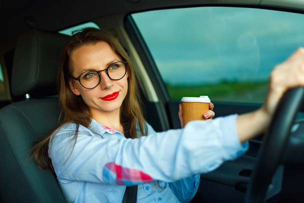 Жінка з кавою, щоб піти за кермом своєї машини
 - Фото, зображення