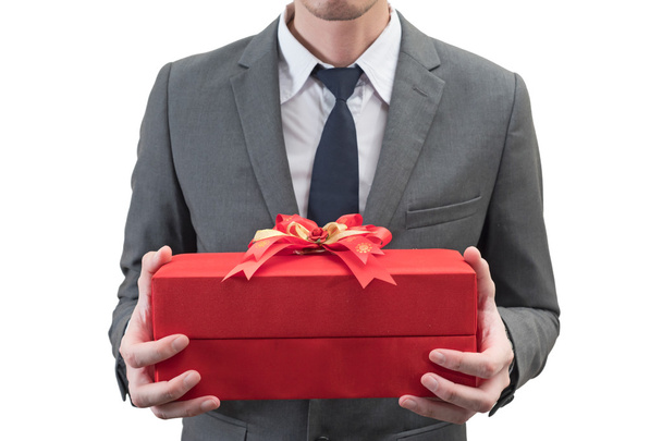Бізнесмен тримає червону подарункову коробку ізольовано на білому тлі
. - Фото, зображення