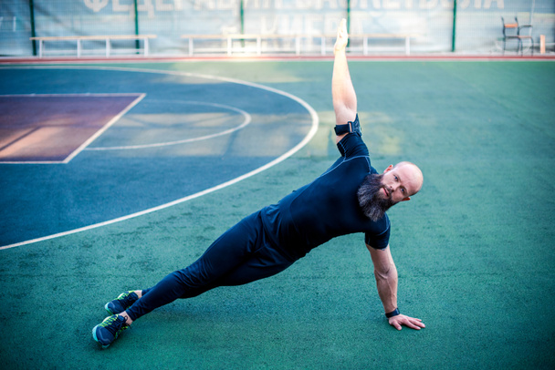Svalnatý muž dělá boční plank - Fotografie, Obrázek