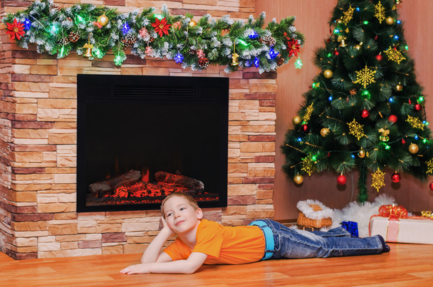Happy boy lying on the floor near the fireplace - Valokuva, kuva