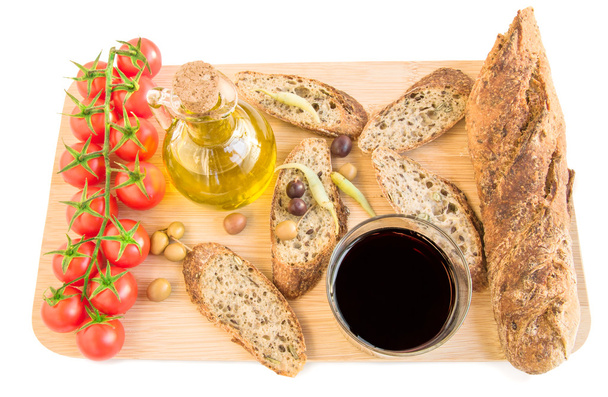 Tray with bread, olives, olive oil, vine, tomatoes on white. - Foto, Imagem
