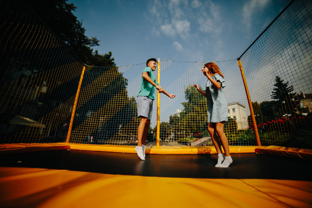 Couple jumping on trampoline in the park - 写真・画像