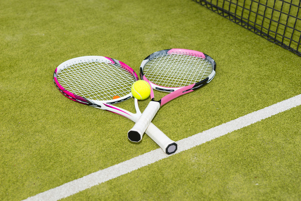 Close-up of two tennis rackets with a tennis ball - Fotó, kép