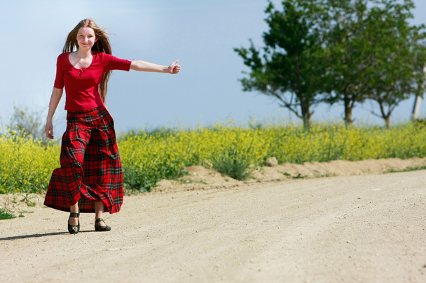 happy girl hitchhiking on country road - Fotó, kép