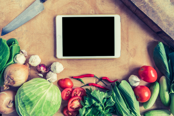 Top view of Fresh vegetables with tablet touch computer gadget on wooden table background. - Valokuva, kuva