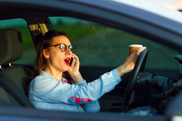 Businesswoman multitasking durante la guida
 - Foto, immagini
