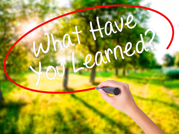 Женщина пишет то, чему вы научились? с маркером над травой
 - Фото, изображение