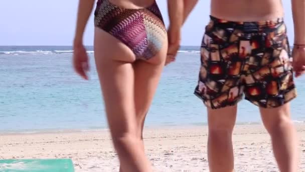 Attractive caucasian couple having fun being together walking on the beach. Happy couple hold each other. Journey to Bali island, Indonesia. Slow motion, Full HD, 50 fps. - Footage, Video