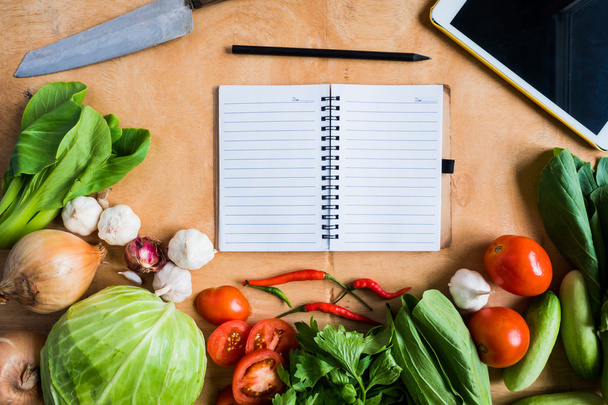 Draufsicht auf frisches Gemüse mit leerem Notizbuch auf Holztischhintergrund. - Foto, Bild