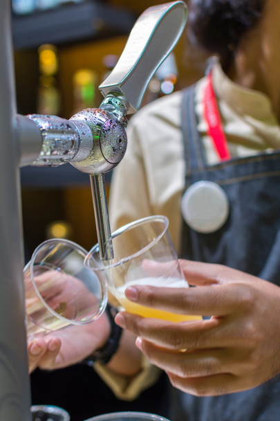 Barman ou barman derramando uma cerveja lager calado de torneira de cerveja
 - Foto, Imagem