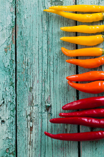 many vibrant colors on peppers , old wooden background - Valokuva, kuva
