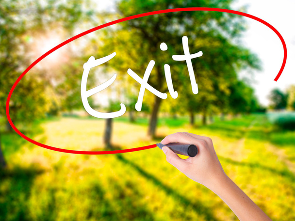 Woman Hand Writing Exit with a marker over transparent board  - Photo, Image