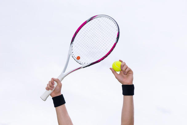 Human hands holding tennis ball and a racket on background of th - Photo, Image