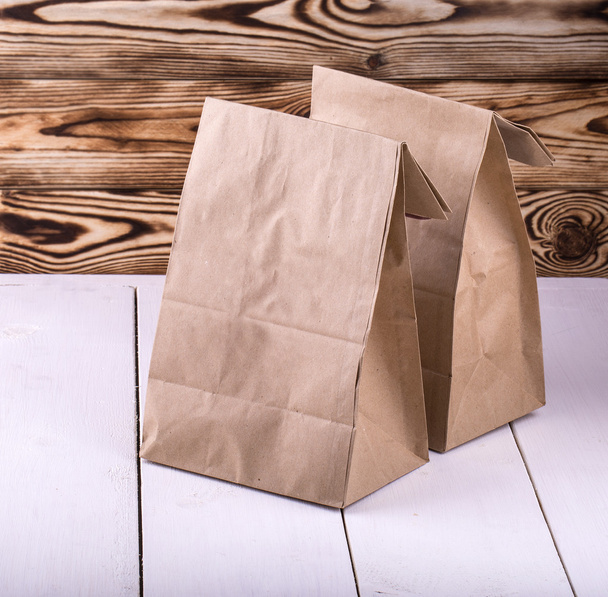 Καφέ τσάντα μεσημεριανό γεύμα στο λευκό ξύλινο τραπέζι  - Φωτογραφία, εικόνα