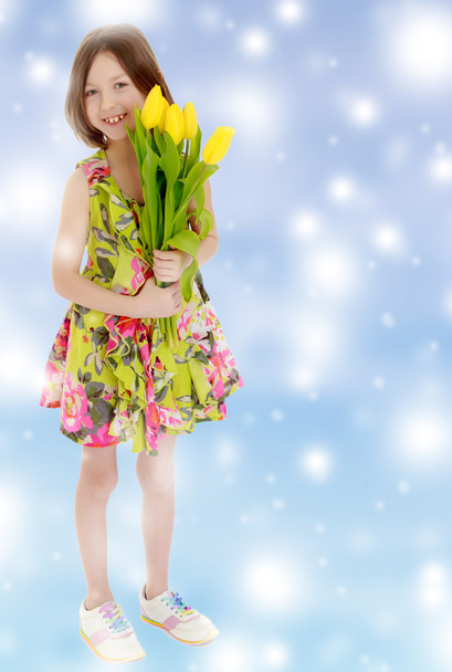 petite fille avec un bouquet de tulipes jaunes
. - Photo, image