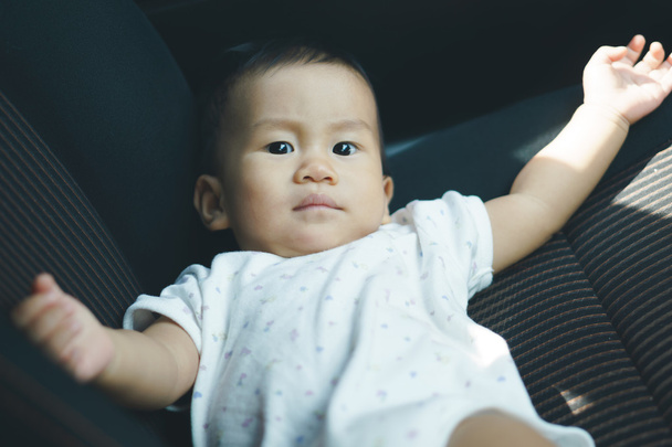 Asiatico bambino lies oltre auto seat
 - Foto, immagini