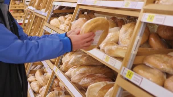 facet wybrać świeże wypieki w supermarkecie - Materiał filmowy, wideo