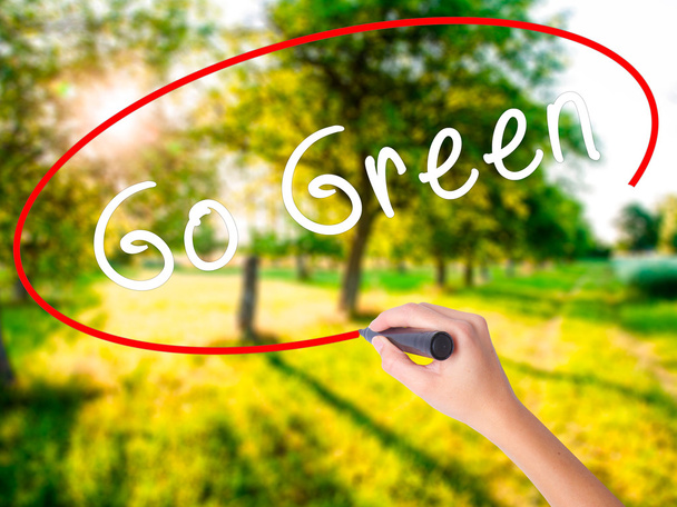 Nainen Käsi Kirjoittaminen Go Green merkki yli läpinäkyvä aluksella
 - Valokuva, kuva