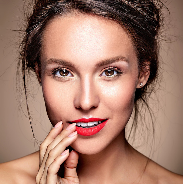 portrait of beautiful woman model with fresh daily makeup and red lips and healthy skin touching her mouth - Zdjęcie, obraz