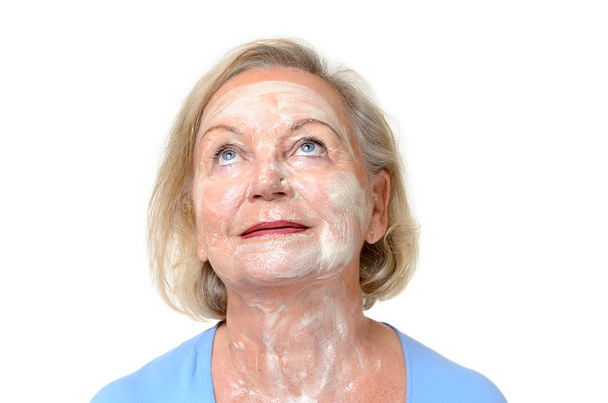 Smiling elderly lady with face cream on her skin - Photo, Image