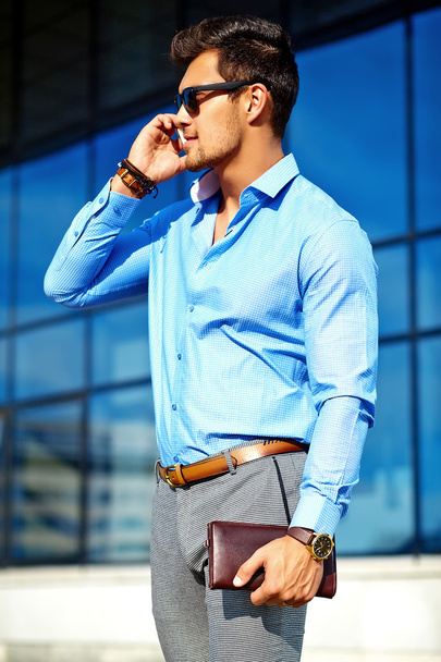 Fashion portrait of young sexy businessman handsome model man in casual cloth suit in sunglasses in the street speaking on his phone - Zdjęcie, obraz