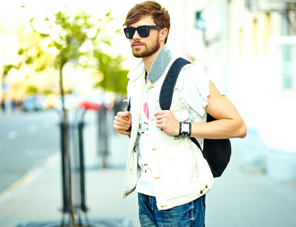 Funny smiling hipster handsome man in stylish summer clothes posing on street background  - Foto, afbeelding