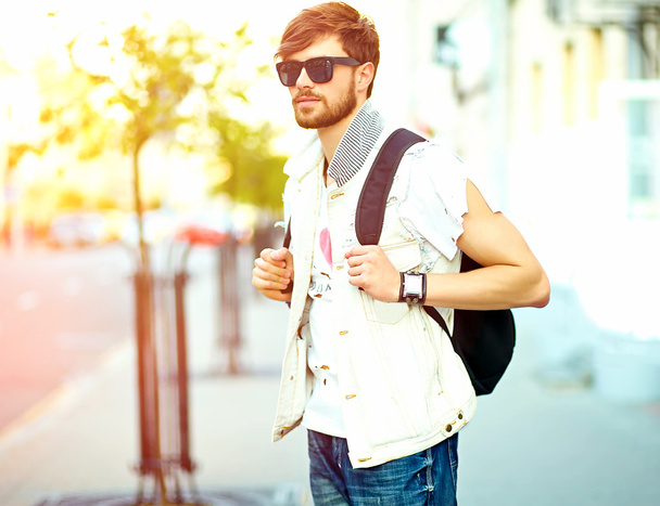 lustig lächelnder Hipster gutaussehender Mann in stylischer Sommerkleidung posiert vor Straßenhintergrund  - Foto, Bild