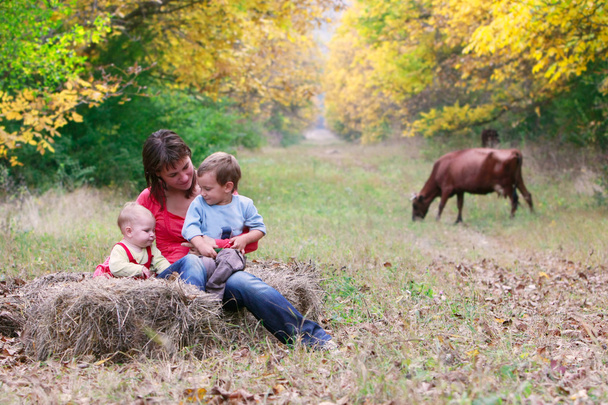ευτυχισμένη μητέρα με δύο παιδιά στο πάρκο φθινόπωρο - Φωτογραφία, εικόνα