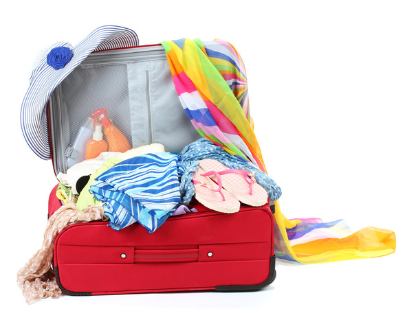 Suitcase with summer clothes, a hat and suntan isolated on white - Foto, Imagem
