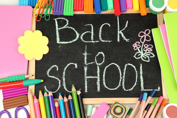 The words 'Back to School' written in chalk on the small school desk with v - Foto, Imagen