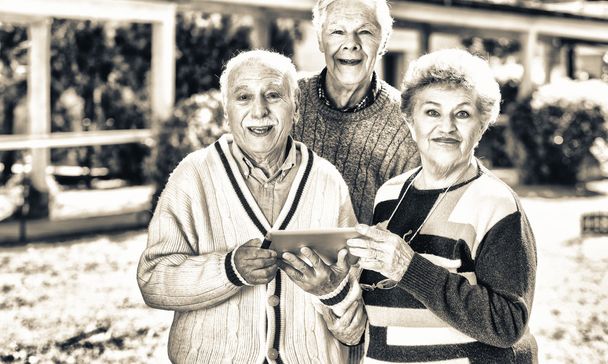 Three elder people using tablet outdoor - Zdjęcie, obraz