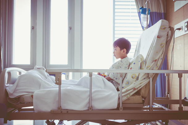 Азиатский ребенок госпитализирован в палате с инфузионным насосом внутривенно IV капельницы
. - Фото, изображение