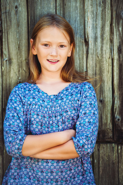 Portrait d'une jolie petite fille de 8-9 ans, vêtue d'une robe bleue
 - Photo, image